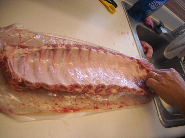 Freshly rinsed rack of ribs showing shiny membrane
